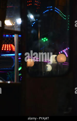 Primo piano di una piccola casa nel parco dei divertimenti con luci che riflettono sul vetro Foto Stock