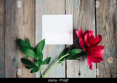 Peonia fiore e vuota del foglio di carta su sfondo di legno Foto Stock