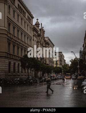 Uomo che cammina in un giorno di pioggia. Foto Stock