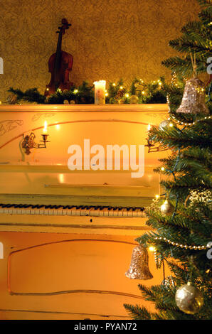 Albero di natale con le bollicine sullo sfondo di un vecchio pianoforte Foto Stock