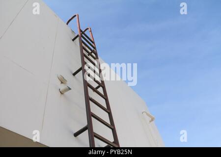 Scala verticale vecchio metallo industriale arrugginita. di acqua del serbatoio n. di rotaie di sicurezza Foto Stock