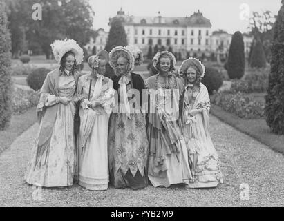 Poke cofani. Un gruppo di cinque giovani donne nel parco di lecci Drottning castello, durante le riprese del film Filmen om Emelie Högqvist 1939. Essi sono tutti abbigliati come signore dell'anno 1835. In particolare i cappelli che sono chiamati Poke cofano che è entrato in voga all'inizio del XIX secolo. Foto Stock