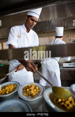 Hotel chef che serve piatti di curry in Mauritius. Foto Stock