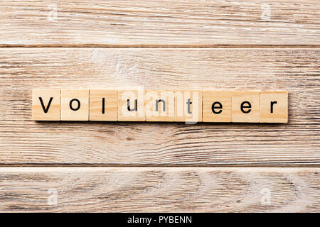 Volunteer parola scritta sul blocco di legno. volontario del testo in tabella, concetto. Foto Stock