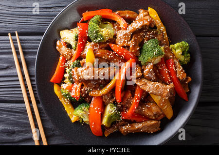 Asian teriyaki manzo con peperone, broccoli e sesamo close-up su una piastra sul tavolo. parte superiore orizzontale vista da sopra Foto Stock