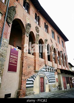 Il vecchio palazzo del vescovo facciata di mattoni rossi sulla piazza principale (Piazza Duomo) a Pistoia, Toscana, Italia. Isolato su bianco sullo sfondo del cielo Foto Stock