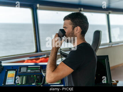 Marine Navigational officer è segnalato da una radio VHF Foto Stock