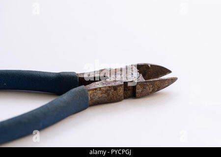 Isolate il vecchio arrugginito pinze con blu scuro manico di plastica. Foto Stock