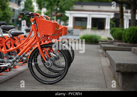 Portland, O / STATI UNITI D'America - 21 Giugno 2018: bike sharing BikeTown programma nel centro cittadino con orange biciclette. Foto Stock