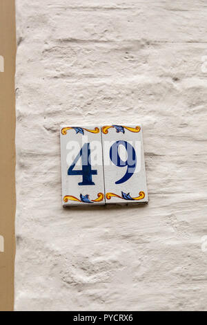 Numero di casa quaranta-ine 49 dipinta su piastrelle di ceramica in blu e giallo, rosso e oro dalla Svezia Foto Stock