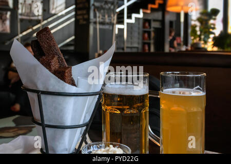Due bicchieri di birra fresca diverse varietà e snack salato, scena reale in pub, bar. Oktoberfest, festa della birra concept Foto Stock