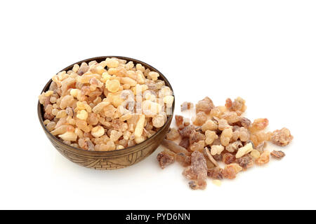 Incenso aromatico in resina di gomma in un vecchio recipiente metallico e allentato su sfondo bianco. Utilizzato in profumeria e industrie di aromaterapia. Le resine di olibanum. Foto Stock