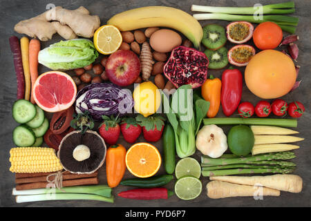 Super food concept per il fitness con frutta fresca e verdure, erbe e spezie e dadi con alimenti ricchi di antiossidanti, antocianine, fibra dietetica. Foto Stock