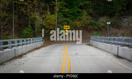 Una svolta a destra segno di freccia avanti indica una curva stretta in una strada Foto Stock