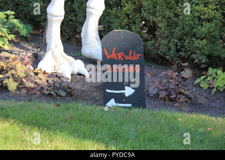 Lupo Mannaro segno di incrocio con due frecce e big artigliato piedi in background come creativi Halloween decorazioni di prato. Foto Stock