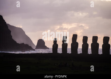 Sunrise a Ahu Tongariki con il motu sul retro, silhouette di sei fifthteen moais Foto Stock