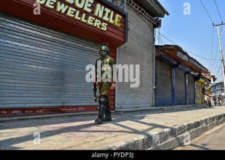 Un soldato di paramilitari visto pattugliano la strada durante il coprifuoco. Valle del Kashmir è sotto controllo il coprifuoco in risposta alla resistenza islamica leader chiamato la popolazione musulmana per contrassegnare 27 Ottobre come una "giornata nera" del Kashmir mentre le autorità indiane sono celebrato come il 71esimo anniversario del dispiegamento delle truppe in Srinagar. Foto Stock