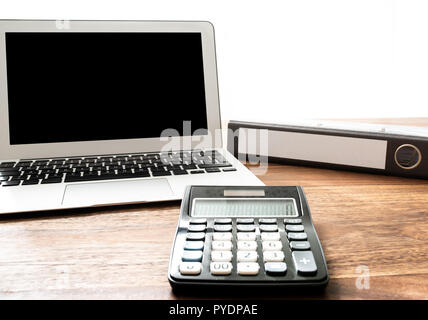 Basso angolo vista della calcolatrice, laptop e file cartella sulla scrivania in legno Foto Stock