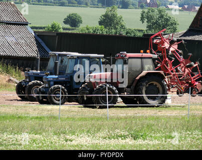 Case International 5150 & Ford 7610 Trattori su una fattoria, Staffordshire, Regno Unito in giugno Foto Stock