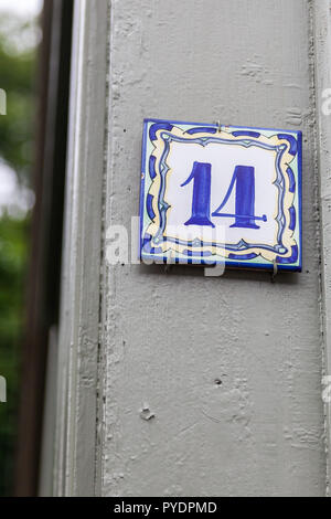 Numero di casa quattordici 14 dipinta su piastrelle di ceramica in blu e giallo da Svezia Foto Stock