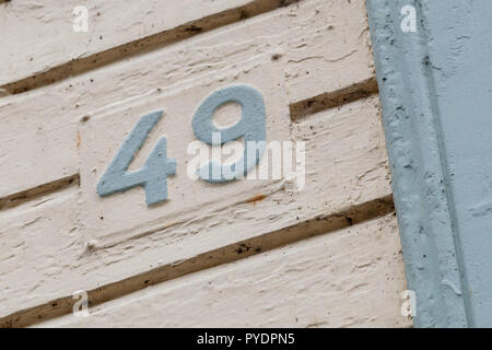 Numero di casa quarantanove 49 in lamiera metallica weathered e rusty dipinte di verde chiaro e crema fissato alla casa weatherboard in Svezia Foto Stock
