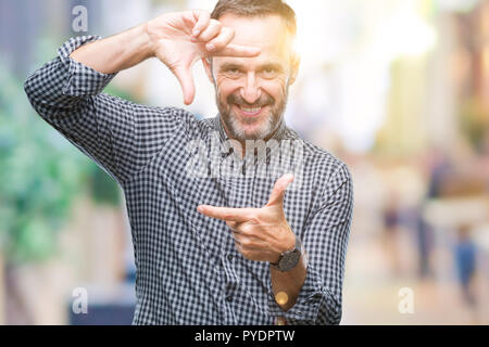 La mezza età annoso senior man over isolato sorridente sfondo rendendo il telaio con le mani e le dita con la faccia felice. La creatività e il concetto di fotografia. Foto Stock