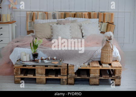 Interni moderni e decor home concept. con cuscini e una coperta, candele. Una grande stella delle lampade. cervi sui cuscini in legno. Foto Stock