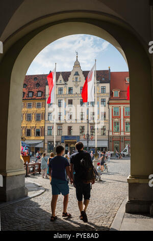 Wroclaw in Polonia, in vista di due giovani uomini polacco immettendo il colorato mercato Square (Rynek) nella centrale area della Città Vecchia di Wroclaw, Polonia. Foto Stock