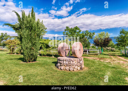 Antico frantoio con due macine in campagna Foto Stock