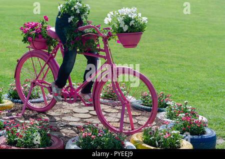 Divertimento rosa è in bicicletta nel parco.Modello di una vecchia bicicletta dotata con cesto di fiori Foto Stock