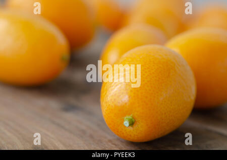 Orange kumquat frutto su sfondo di legno Foto Stock