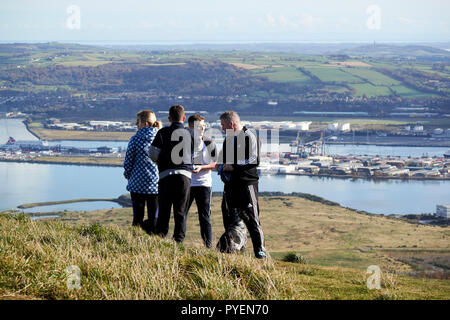 Turisti ed escursionisti di cane su mcarts fort alla sommità della grotta di collina che si affaccia su belfast su una soleggiata domenica mattina, Belfast, Irlanda del Nord Foto Stock