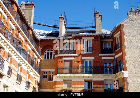 Parigi, Francia, i dettagli del tardo ottocento appartamento edificio rifinito in giallo e rosso cotto, rough-cast di pietra, con eleganti balconi in ferro battuto Foto Stock