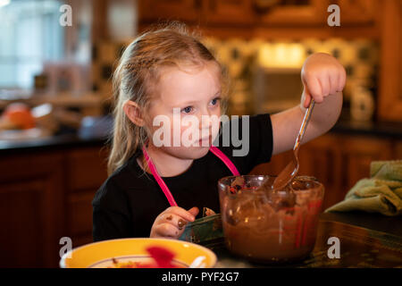 Bambina Fonde il cioccolato per rendere Halloween tratta Foto Stock