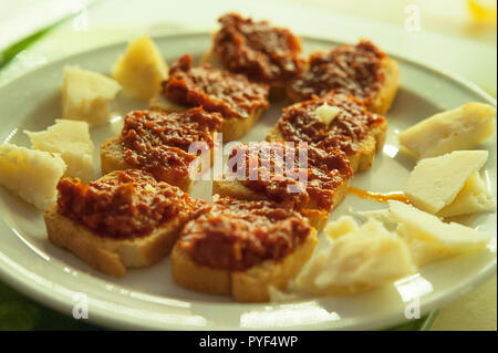 Ampia scelta di tapas con formaggio Manchego e bite-size toast con peperoncino rosso secco e il concentrato di pomodoro su una piastra, un tradizionale spagnolo o piatti mediterranei Foto Stock