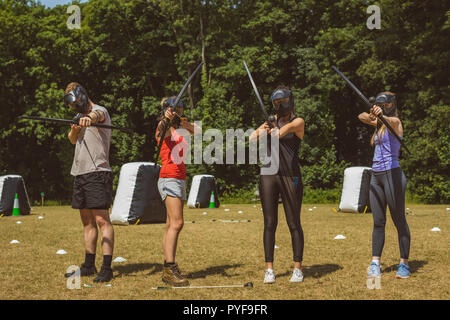 Gruppo di persone che praticano il tiro con l'arco a boot camp Foto Stock