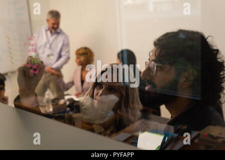 I dirigenti la scrittura sulla parete di vetro Foto Stock