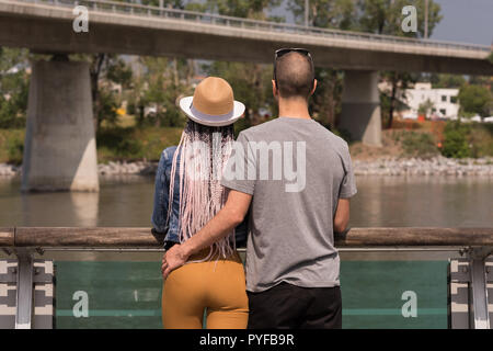 Matura in piedi vicino alla ringhiera a guardare il fiume Foto Stock