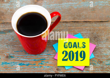 2019 obiettivi - la grafia in inchiostro nero su un foglietto adesivo con una tazza di caffè, propositi per l'anno nuovo concetto. Foto Stock