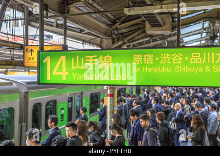 Tokyo, Giappone - 17 Aprile 2017: verde linea Yamanote cartello per Harajuku, la più importante linea ferroviaria in Tokyo. La Folla di pendolari in attesa del convoglio ferroviario presso il Tokyo stazione ferroviaria principale Foto Stock