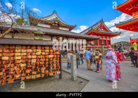 Kyoto, Giappone - 24 Aprile 2017: placche in legno o Ema, Cuscinetto del popolo, prayerspeople donne in kimono prende selfie e pagoda rossa all'interno di Kiyomizu-dera, uno dei più celebri templi del Giappone. Foto Stock