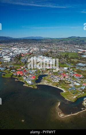 Il lago di Rotorua, Ohinemutu villaggio Maori e il centro della città, a Rotorua, Isola del nord, Nuova Zelanda - aerial Foto Stock