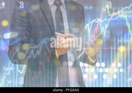 La doppia esposizione di imprenditore utilizzando smart tablet oltre la schermata di morbida del mercato azionario sfondo, business concetto di trading Foto Stock