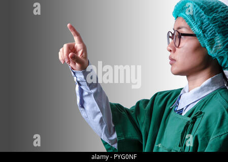 Medico tenendo il dito indice per toccando schermo su uno sfondo grigio con tracciato di ritaglio Foto Stock