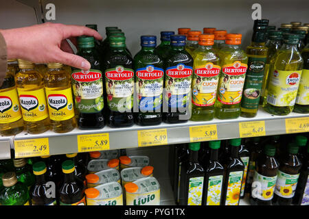 Vari oli di cottura bottiglia, come olio di oliva, sono visualizzate in uno scaffale di supermercato Foto Stock
