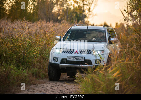 Mitsubishi Pajero Sport e alberi in autunno in una giornata di sole. Khabarovsk, Russia. Ottobre 12, 2018 Foto Stock