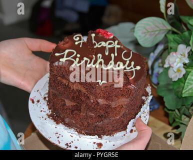 Close up di un chomped su mezza doppia mangiato cioccolato torta di compleanno fortemente indicando una completa mancanza di forza di volontà Foto Stock