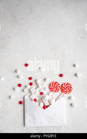 Composizione di Natale con dolci e avvolgono, piatto giaceva sul bianco, copia dello spazio. Auguri di Natale carta con caramelle. Foto Stock