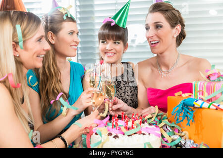 Quattro belle e vivaci donne tostare con champagne Foto Stock