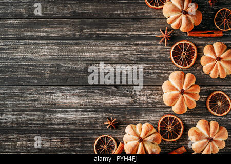 Torte fatte in casa a forma di zucca e arance essiccato sul legno scuro backgroundm vista superiore con spazio di copia Foto Stock